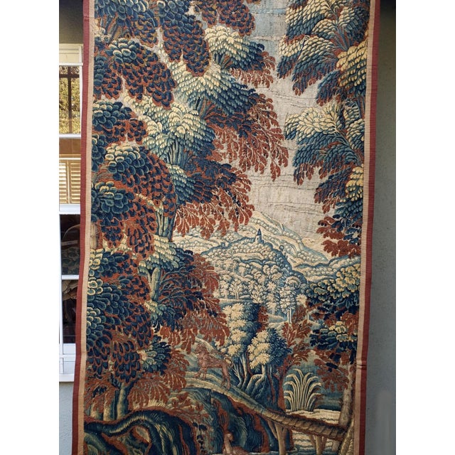 A beautiful early 18th-century verdure tapestry depicting a lush, wooded landscape with a duck in the lower portion and a...