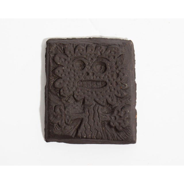 A studio pottery tile by the American artist Mark Bulwinkle (born 1946). This tile depicts the impressed image of a...