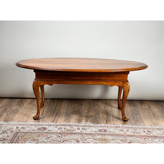 This really great solid cherry coffee table reflects the enduring elegance of the Queen Anne style, likely produced by...