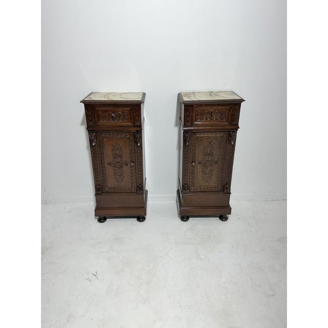 Set of two hand-carved Sicilian bedside tables with marble tops, 1940 Walnut with marble tops. Drawer and door on the...