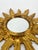 * Sun-shaped * Round mirrors in the center * with a decorated ring directly around the mirrors * Made of wood * Gold-...