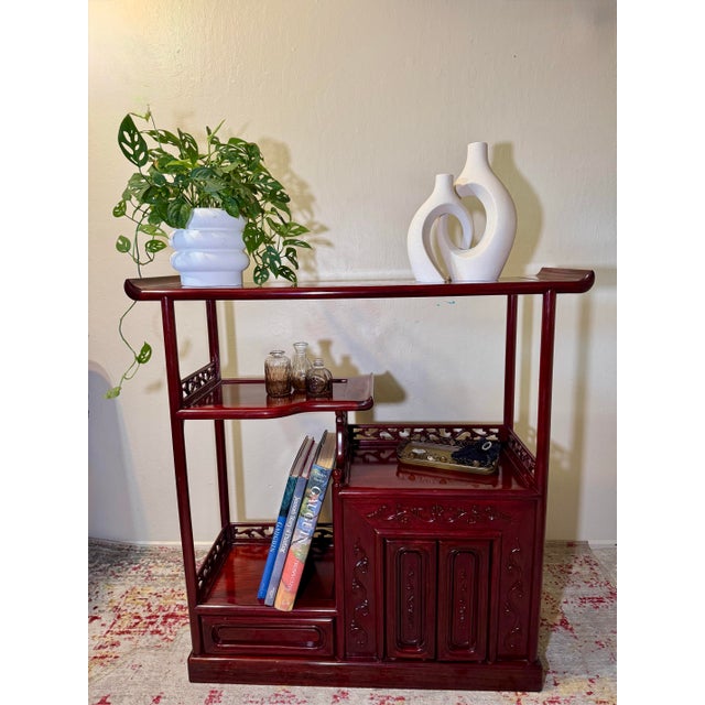 • Hand-carved pierced fretwork galleries in a scrolling foliate motif • A floating upper shelf with its own curled end,...