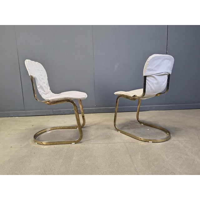 Set of 5 dining chairs from Cidue. The chairs have a beautifully shaped brass frame and come with a beige fabric...