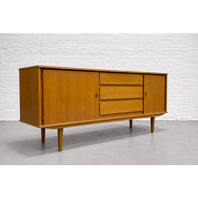 Mid Century Modern Scandinavian sideboard, c. 1960’s. Crafted in oak, the piece showcases beautiful natural grain...