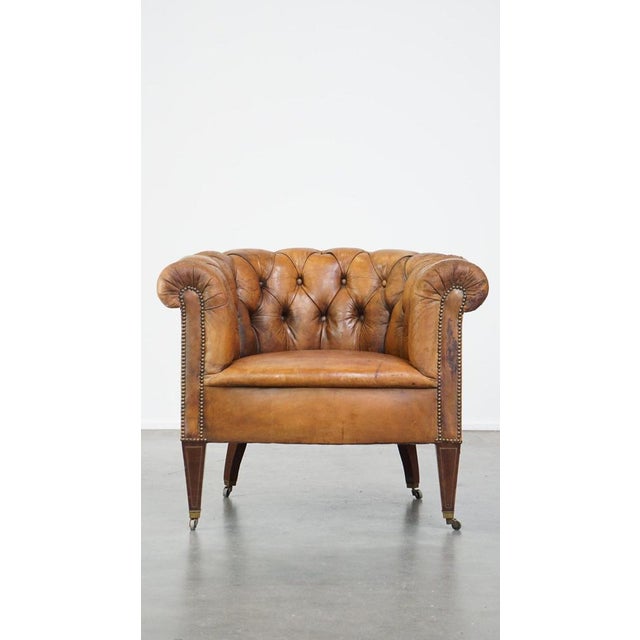 Offered is this antique, characteristic sheepskin chesterfield club chair on wheels. Dimensions: Height: 74 cm Width: 86...