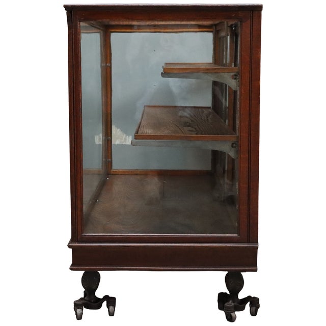 Antique country store display case, circa 1920, constructed of oak with glazed sides and sliding glass doors. The interior...