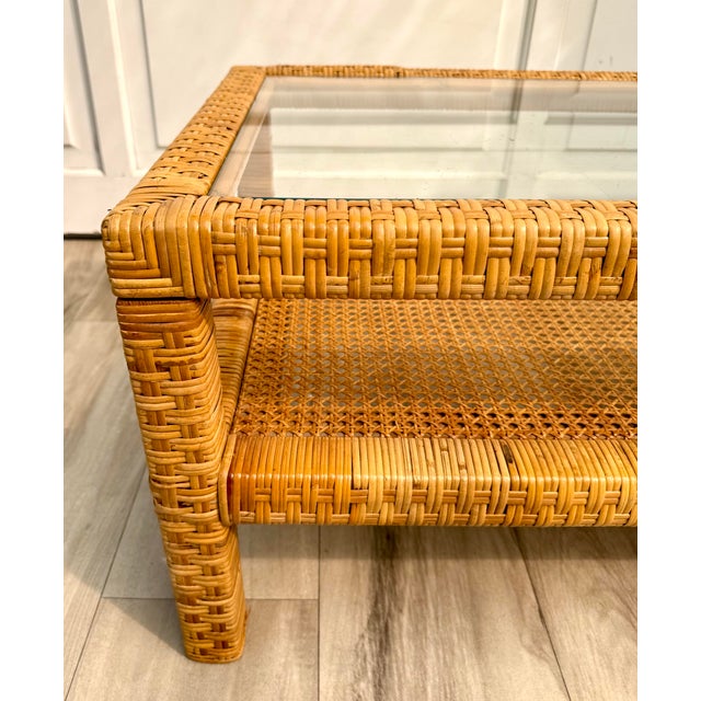 Here is a beautiful later mid-century two-tier coffee table featuring a rectangular woven rattan frame, inset glass top...