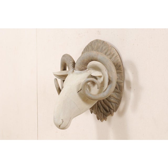 A handsome hand-carved wooden ram's head wall ornament. This artisan created wooden ram's head features a hand-carved,...