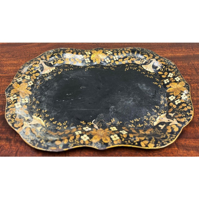 Antique 19th C Toleware tray featuring scalloped edges and hand-painted gold floral motifs on a faded black background....