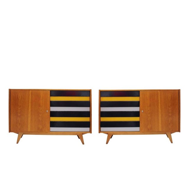 Striking pair of mid-century oak sideboards from 1960s Czechoslovakia. Each piece features four lacquered drawers in...