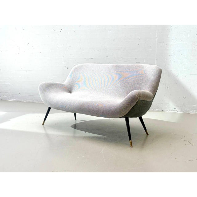 Elegant vintage two-seater sofa in the characteristic mid-century style of the 1950s. The design is distinguished by its...