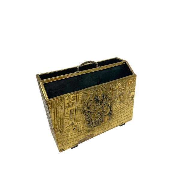 An old brass relief from the 1940s–50s, used as a newspaper holder, featuring an image of an old inn or kitchen interior....