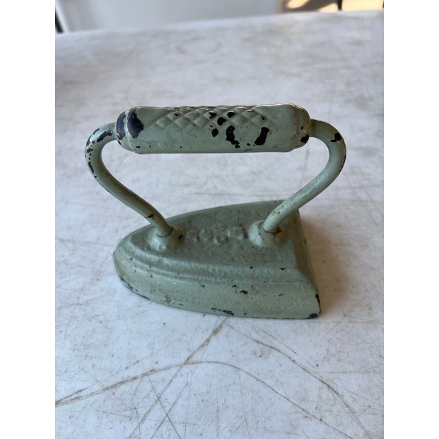 Heavy Cast Iron painted light green. Use as display or door stopper.