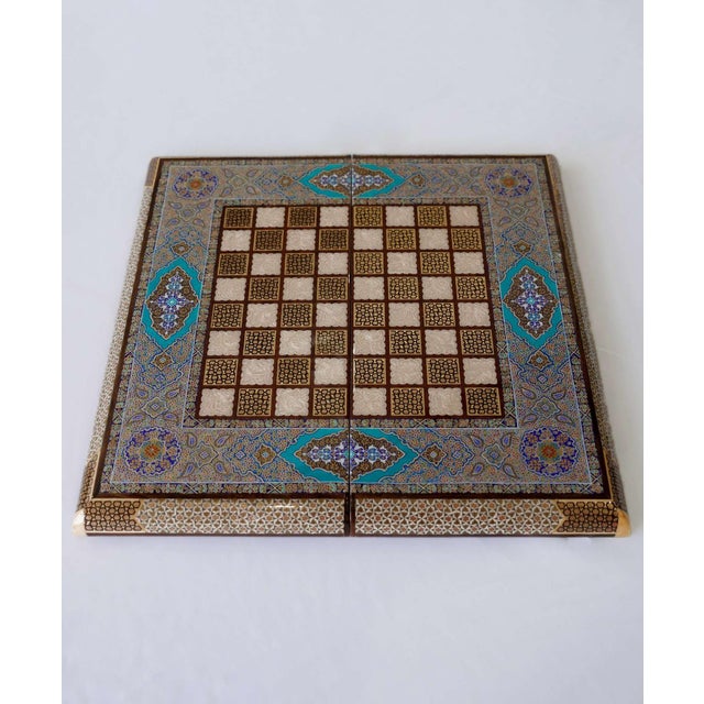 A one-of-one chess and backgammon set combining hand-cut Khatam marquetry with turquoise Tazhib-inspired painting. The...