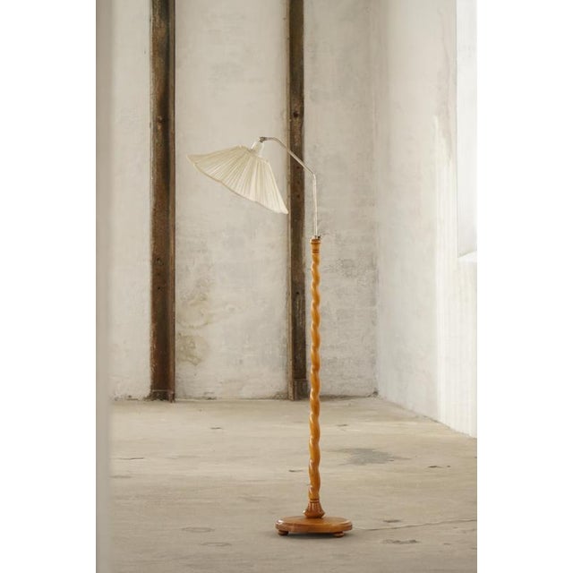 A charming Scandinavian floor lamp featuring a beautifully turned birch wood base, combining traditional craftsmanship...