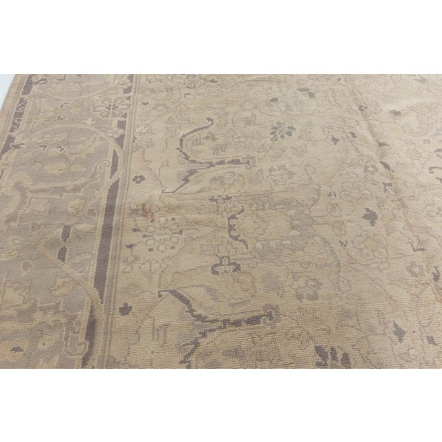 An early 20th-century Indian antique rug, the pale beige field with a subtle allover trellis of leafy split-leaf tendrils,...