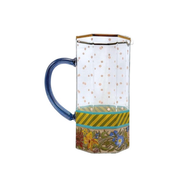 Rare beautiful glass pitcher with a floral base, pink polka dots, and a vibrant blue handle. A stunning addition to...
