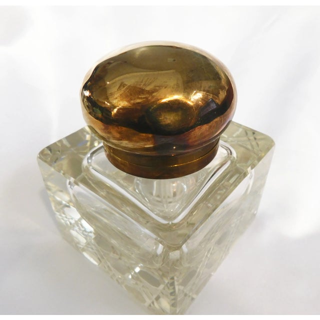 This is a large and I think older crystal inkwell that has some discoloration. It has an attached metal lid with an...