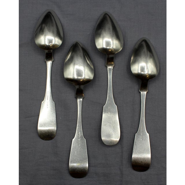 Set of four coin silver place spoons by G.O. Conrad, mid-19th century. Fiddle pattern; well pointed tips; script monogram...