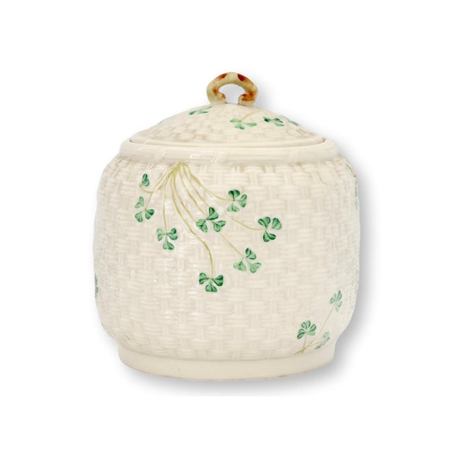 A charming Irish Belleek biscuit barrel in the beloved Shamrock pattern, featuring the classic woven basket texture...