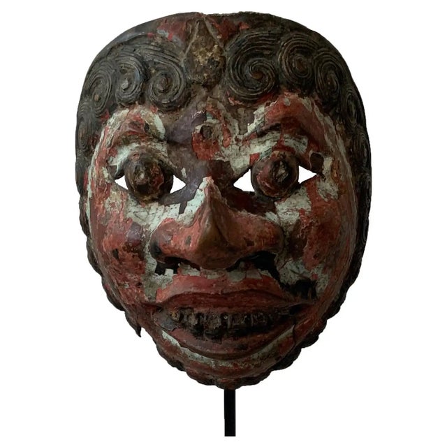 A visibly old mask from the Javanese masks theatre ‘wayang topeng’: carved from hard wood, and painted on the front side....