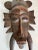 This striking vintage African mask is a hand-carved wooden piece with bold geometric detailing and deep tribal symbolism....