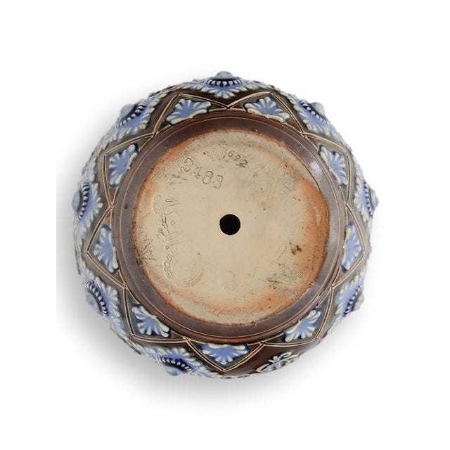 Early twentieth century Royal Doulton art pottery match striker with richly molded blue floral decoration and integral...