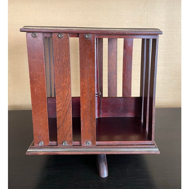 A rare rotating book stand of early 20th-century origin, distinguished by its architectural form, kinetic function, and...