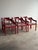 Set of six vintage sculptural dining chairs in a deep red lacquered finish. Rounded cylindrical legs with softly curved...