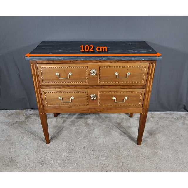 Louis XVI chest of drawers in solid walnut and light and stained wood marquetry, equipped with two large drawers whose...