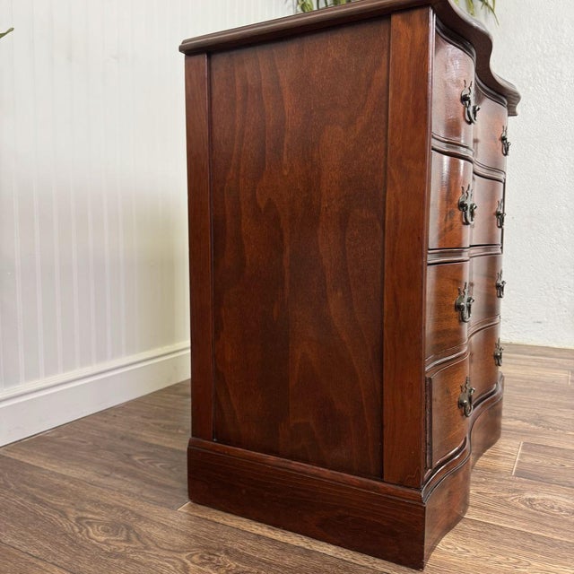 Beautiful vintage serpentine-front chest of drawers in a rich mahogany finish. This piece features original brass hardware...
