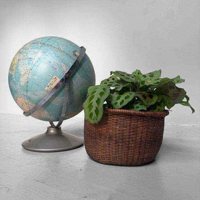 A decorative Japanese globe on a metal stand, with a soft blue map design, Japanese place names and a refined educational...