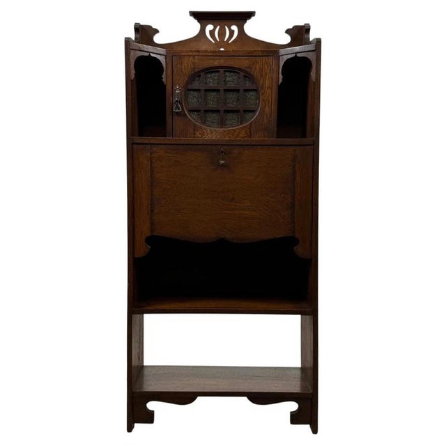 A beautifully designed and highly practical 20th-century Arts and Crafts oak bureau, combining glazed display space, a...