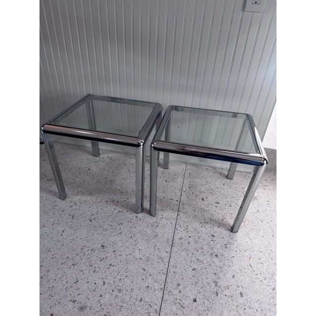 A fabulous pair of vintage chrome and glass end tables dating to the 1970s. Each table features a sleek architectural...