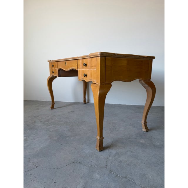Elegant vintage French Provincial–style writing desk featuring graceful cabriole legs, a scalloped apron, and a...