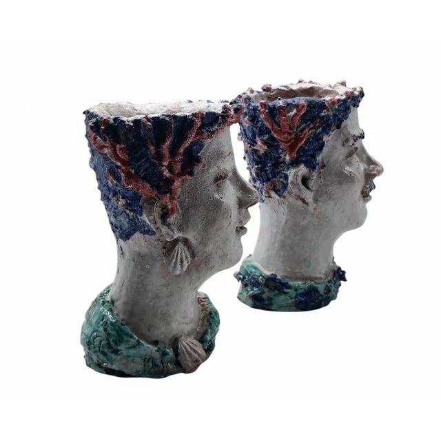 Glazed ceramic sculptures in the form of bust-vases, characterised by stylised faces and polychrome details in relief. The...