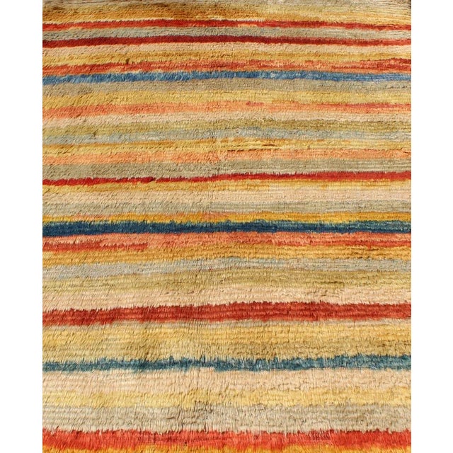 This amazing angora Tulu rug is handwoven from fine angora wool in a soft and colorful palette, featuring a striped...