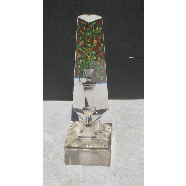 Optical topiary urn cut into a crystal obelisk to create, by reflection and illusion, an urn on pedistal with flowers...