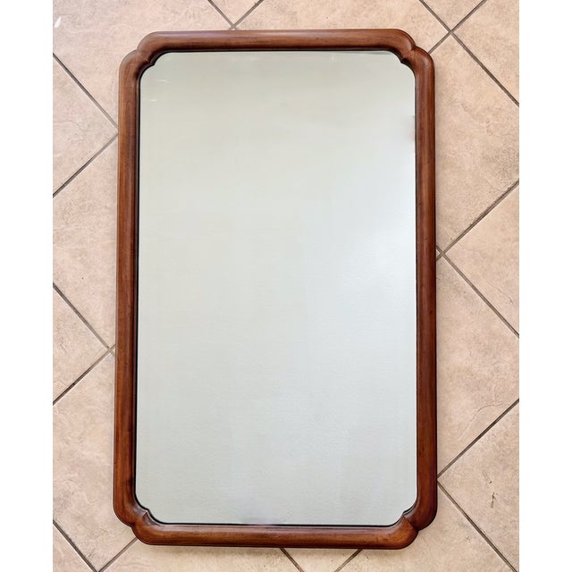 Sleek mid-century Asian inspired walnut wood finish wall mirror by John Stuart for John Widdicomb.