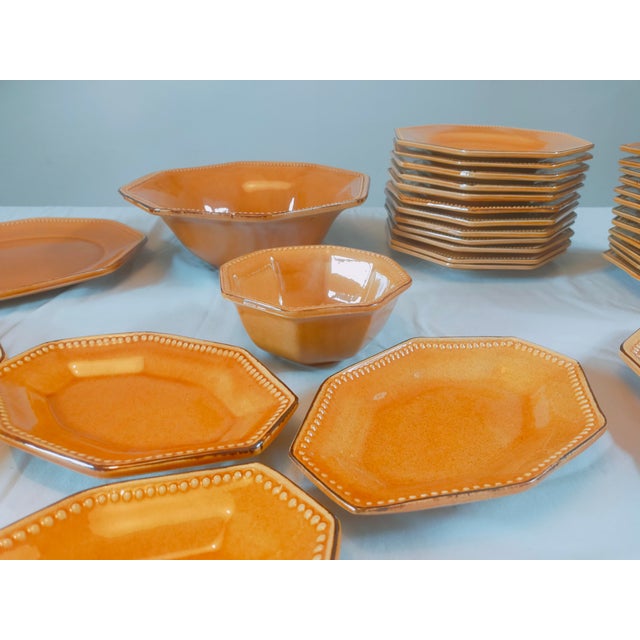 Dinner service comprising 24 dinner plates, 24 side plates, 3 platters, 3 serving dishes and 3 ramekins. In a very bright...