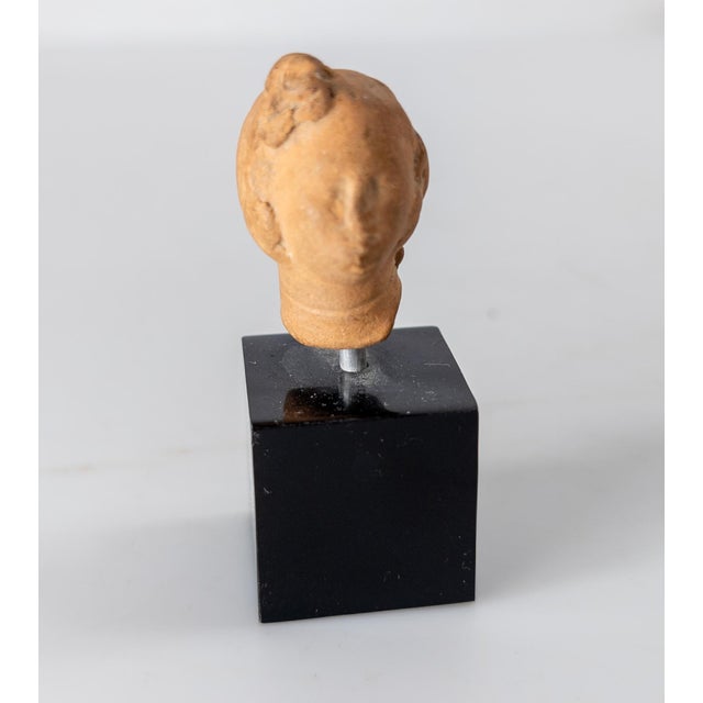 We are selling this small Greek, Roman or Hellenistic fragment. This pottery redware fragment is the head of a female,...