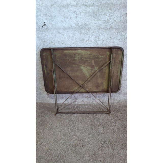 Folding garden table in a bistro/guinguette style, likely dating from the 1900s-1930s. The rectangular metal tabletop has...
