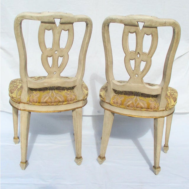 Pair of Italian carved ribbon back side chairs with gilded details and a spaded leg. Upholstered in Scalamandre fabric...