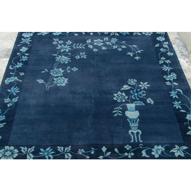 This 5x5 Chinese Art Deco square rug is hand-knotted in wool, with a deep blue field framed by a delicate floral border....
