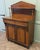 Petite Victorian Mahogany Chiffonier. The cupboard has an architectural pointed pediment and a single shelf supported by...