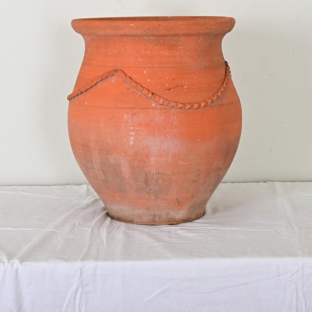 A gorgeous terracotta planter from France, early 20th century, more modern than Mediterranean in its design A thin swag of...