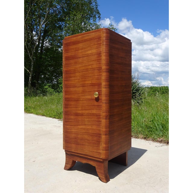 A tall, narrow cabinet with rounded front corners, designed to hold 33 RPM vinyl records, but could be repurposed as an...