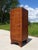 A tall, narrow cabinet with rounded front corners, designed to hold 33 RPM vinyl records, but could be repurposed as an...