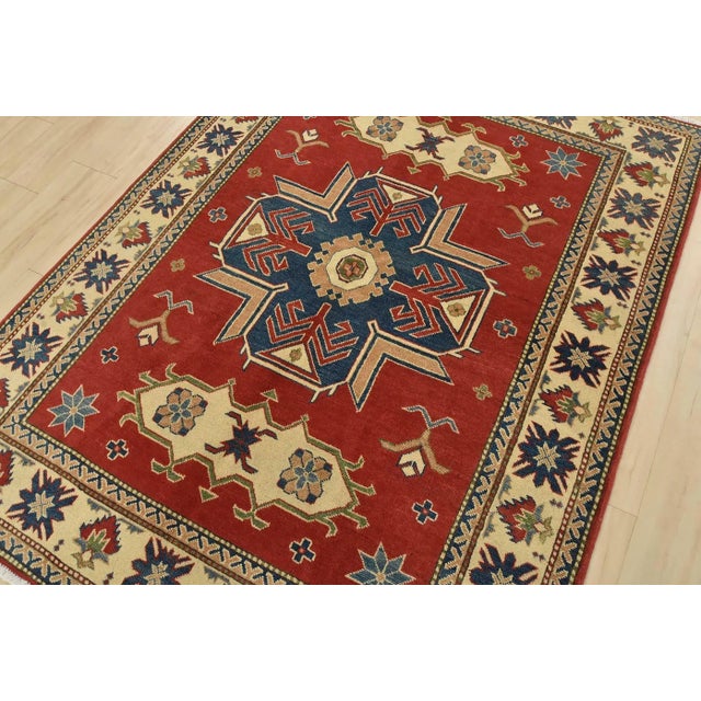 A traditional tribal Caucasian Kazak rug hand-knotted with an all-wool pile on a cotton foundation. This oriental rug...
