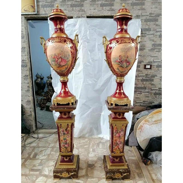 Make a striking statement with this exquisite French-style porcelain vase on pedestal, featuring a rich burgundy finish...